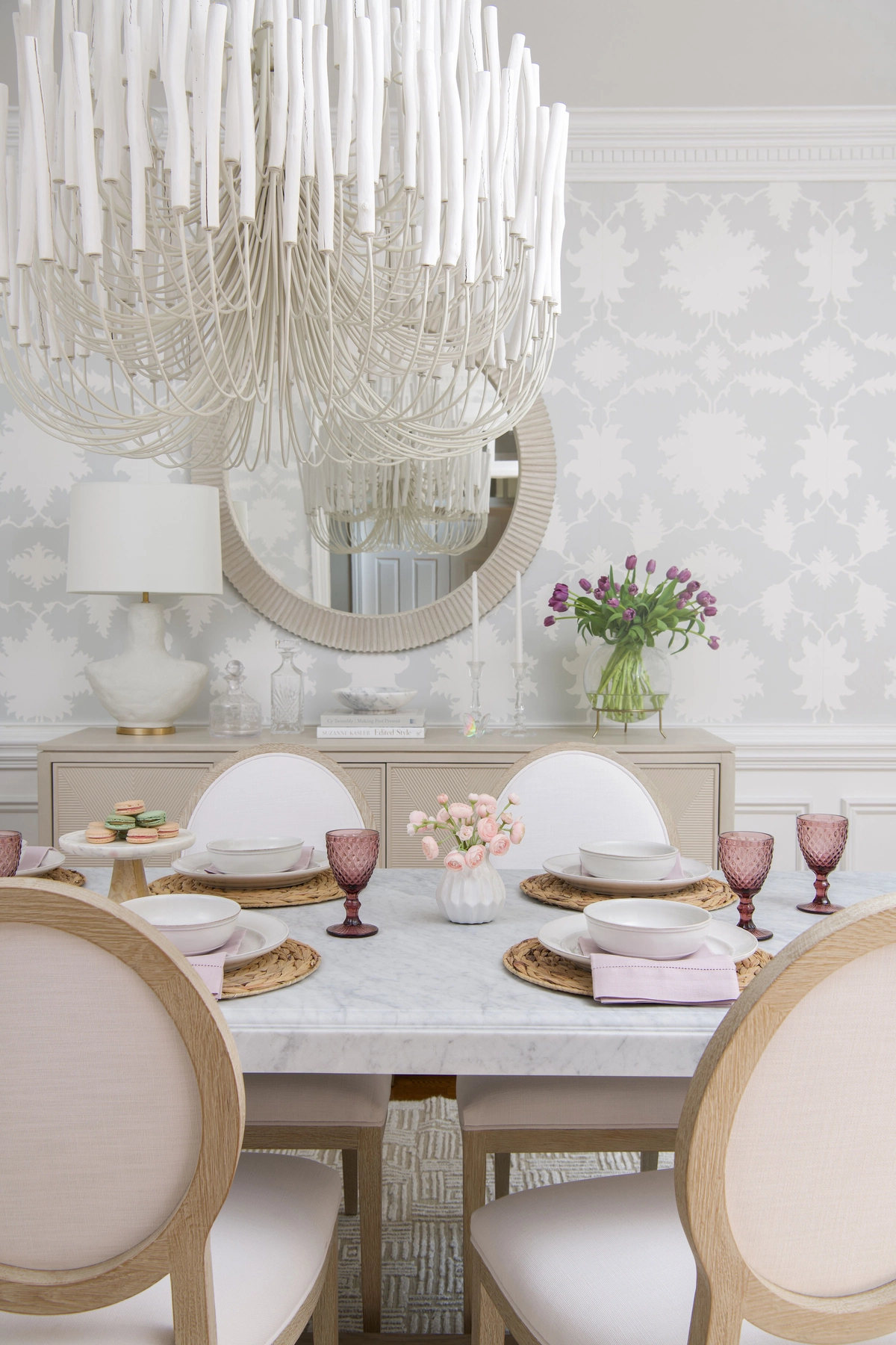 Overhead view of the dining table with chandelier, marble surface, and rose-tinted goblets