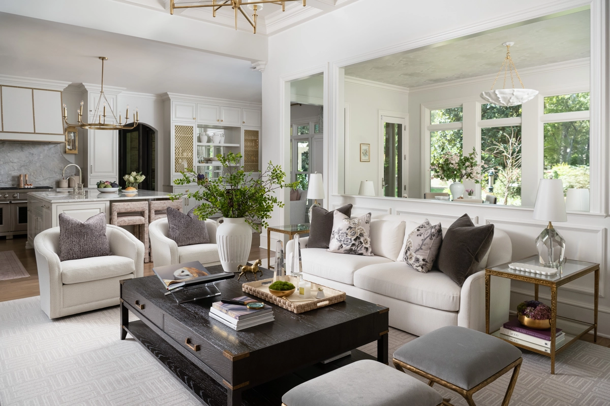 Open-concept living and kitchen area with neutral tones, comfortable seating, and seamless flow between the living space and a bright white kitchen