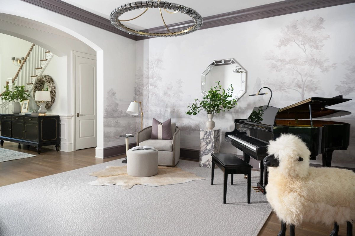 Grand entryway view into the piano room with a black grand piano, gray tree mural wallpaper, an arched doorway with a dark credenza, and a circular brass chandelier