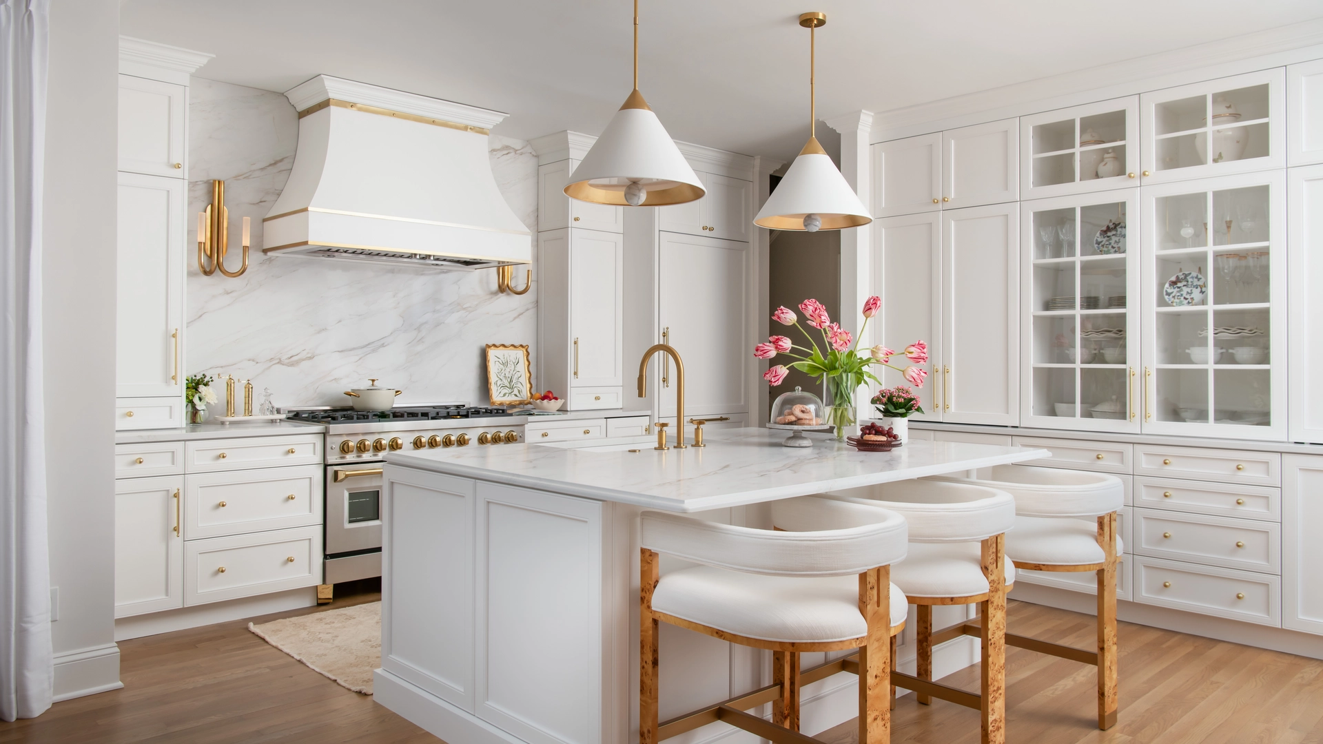White kitchen with gold pendant lights and brass hardware